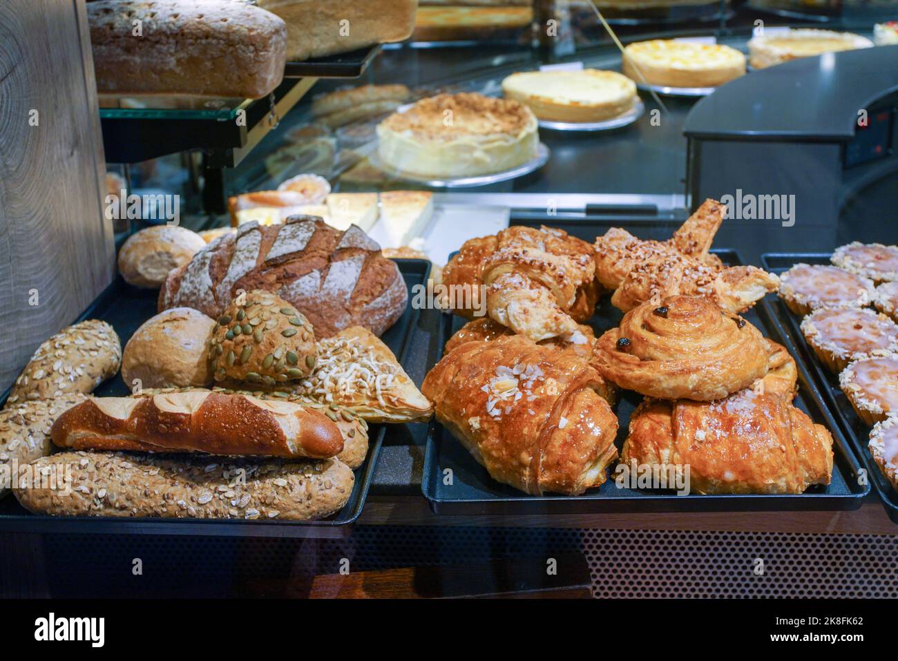 Panini dolci e pane di vario tipo e dolci più grandi sul retro del banco all'interno del negozio in Baviera Foto Stock