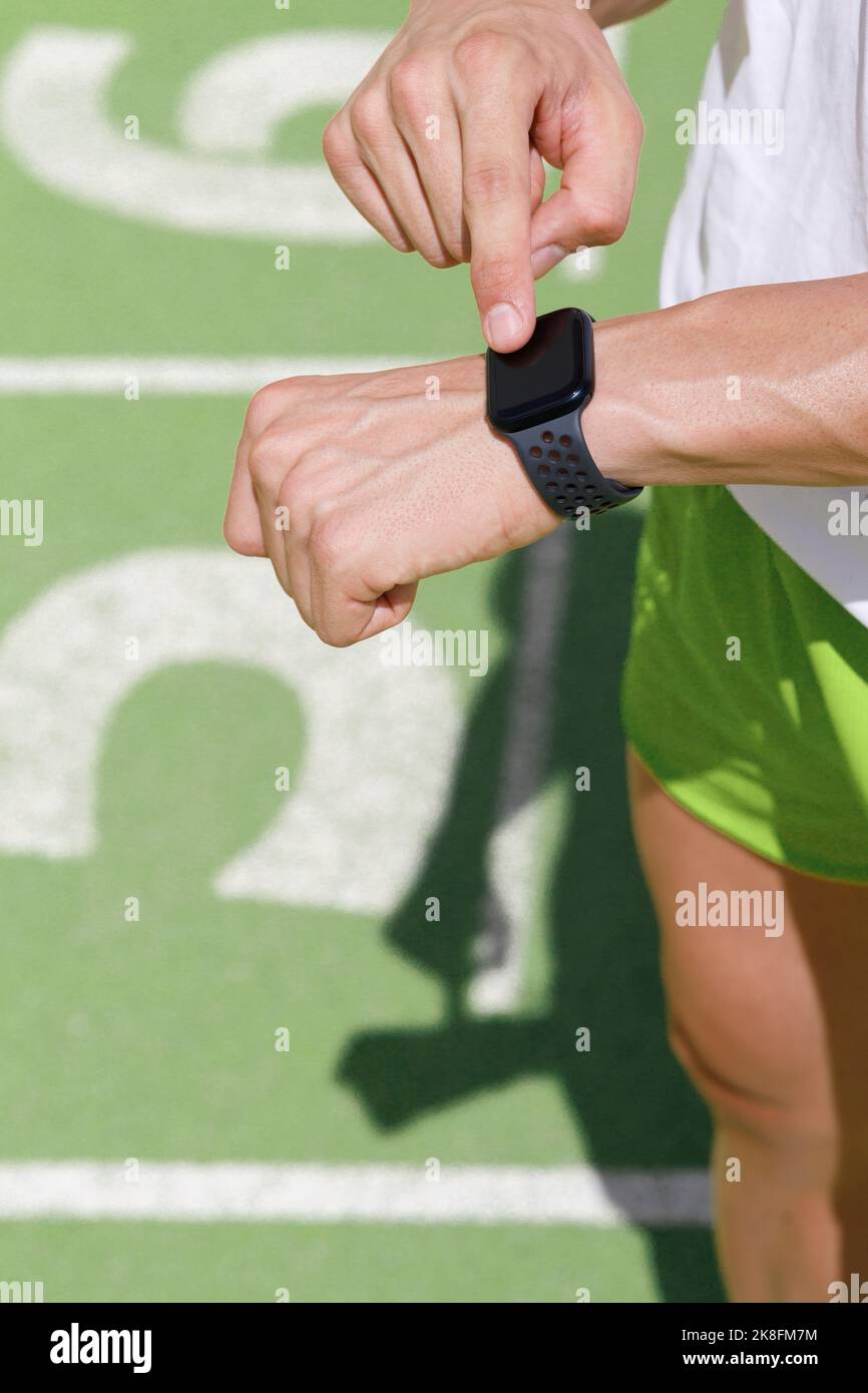 L'atleta controlla il tempo sullo smart watch in pista Foto Stock