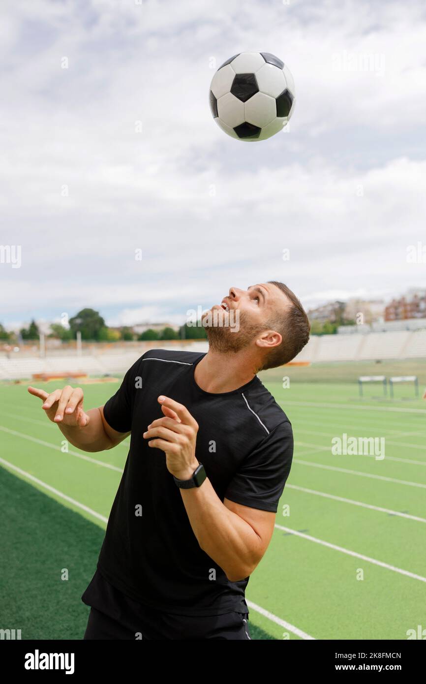 Sportivo attivo che gioca con la palla di calcio Foto Stock