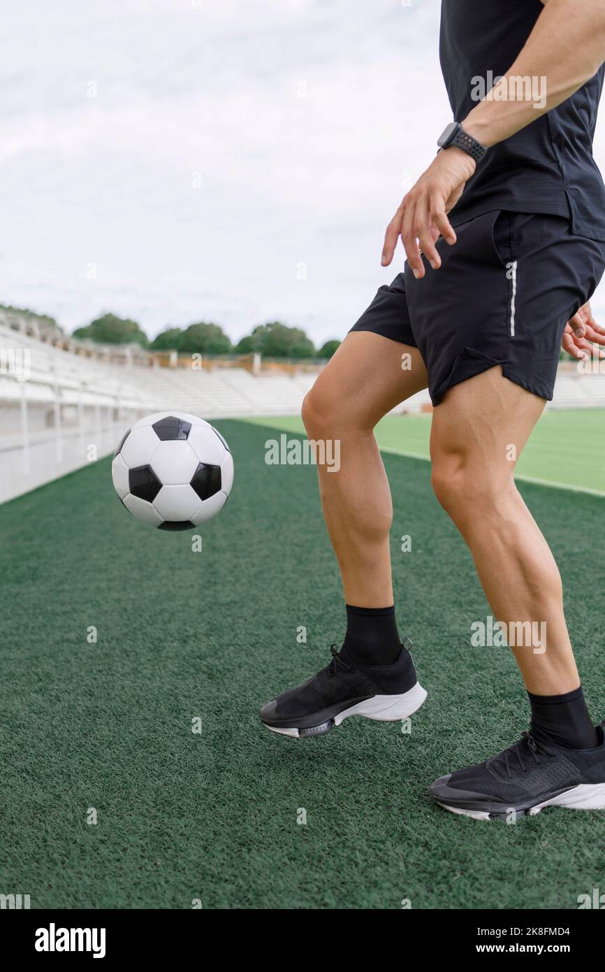 Uomo che gioca con la palla di calcio sul campo Foto Stock