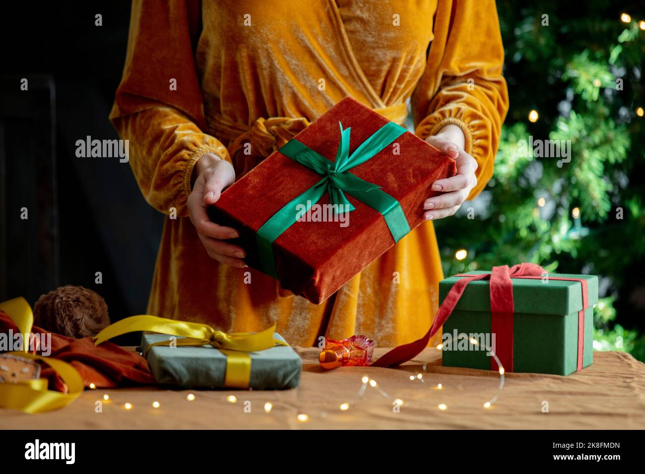 Donna in piedi con regali di Natale a casa Foto Stock