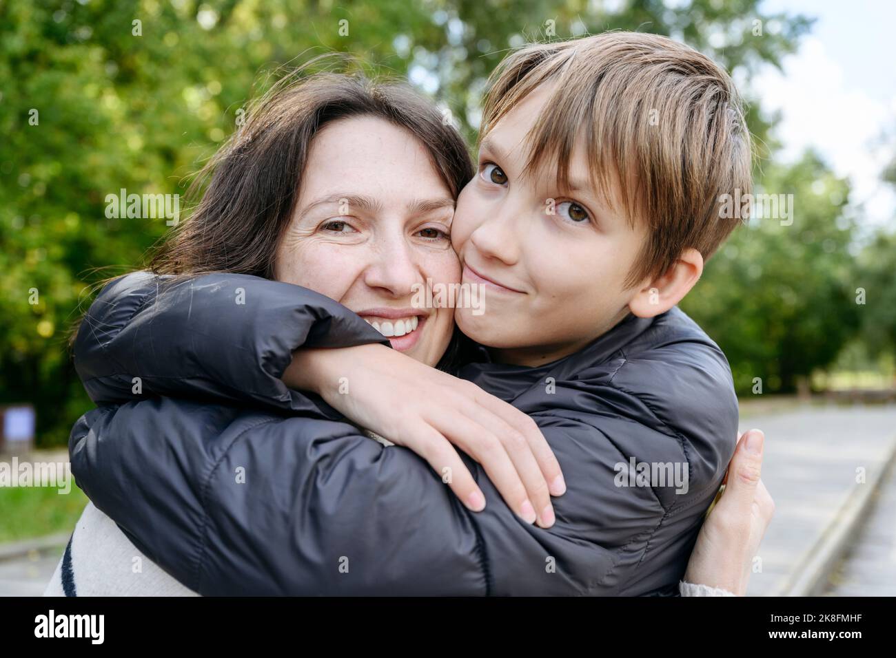 Sorridendo madre e figlio abbracciando nel parco Foto Stock