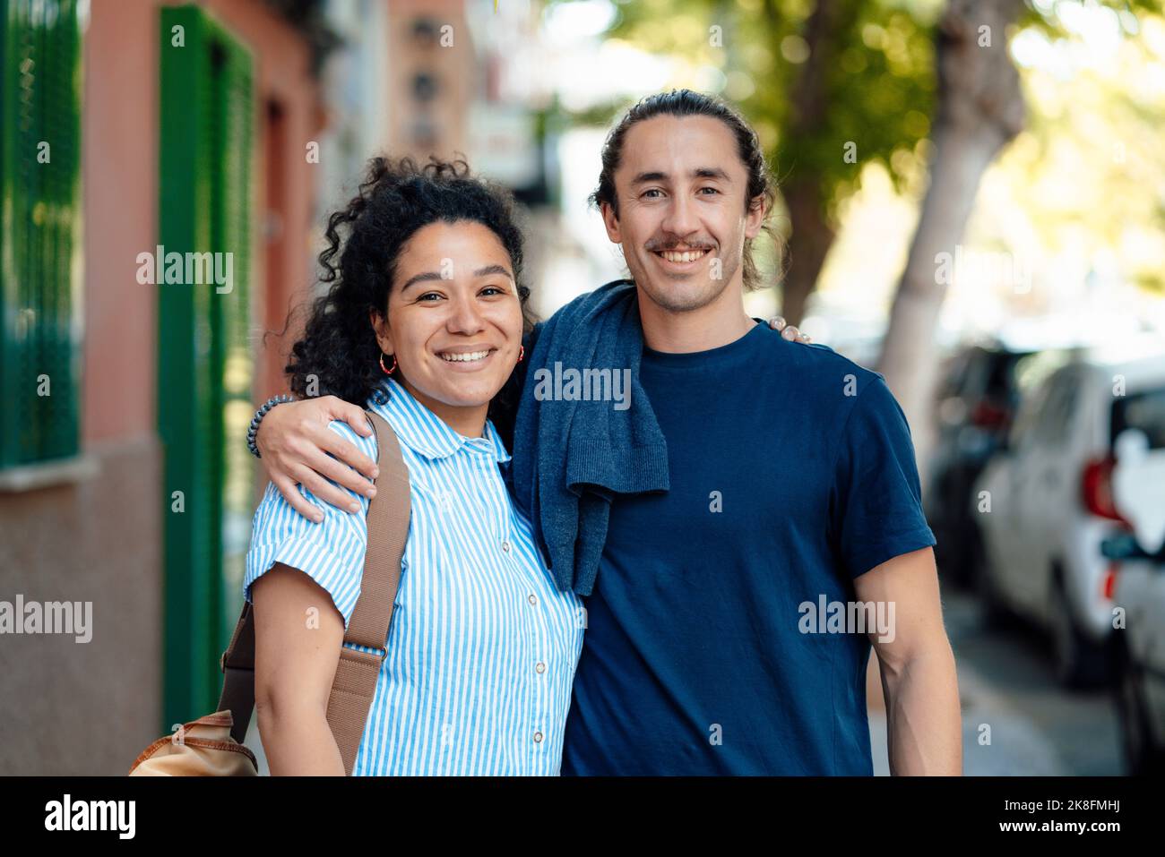 Uomo sorridente braccio intorno alla donna sul sentiero Foto Stock