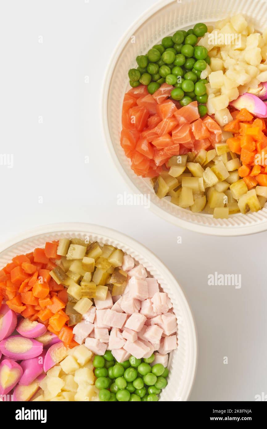 Ciotole con ingredienti Olivier insalata su sfondo bianco Foto Stock