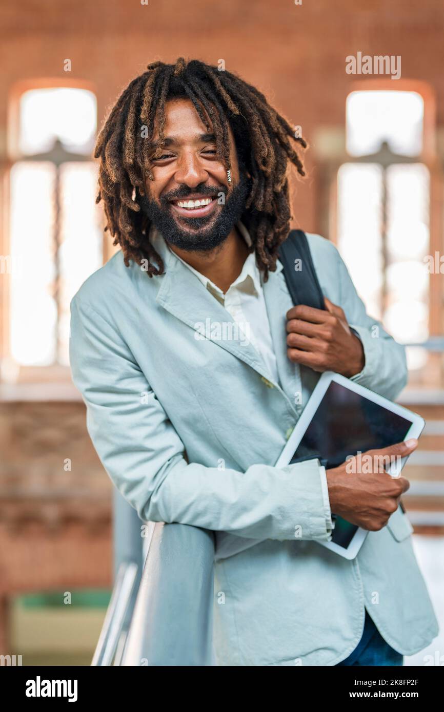 Buon uomo d'affari che tiene un tablet PC alla stazione centrale Foto Stock