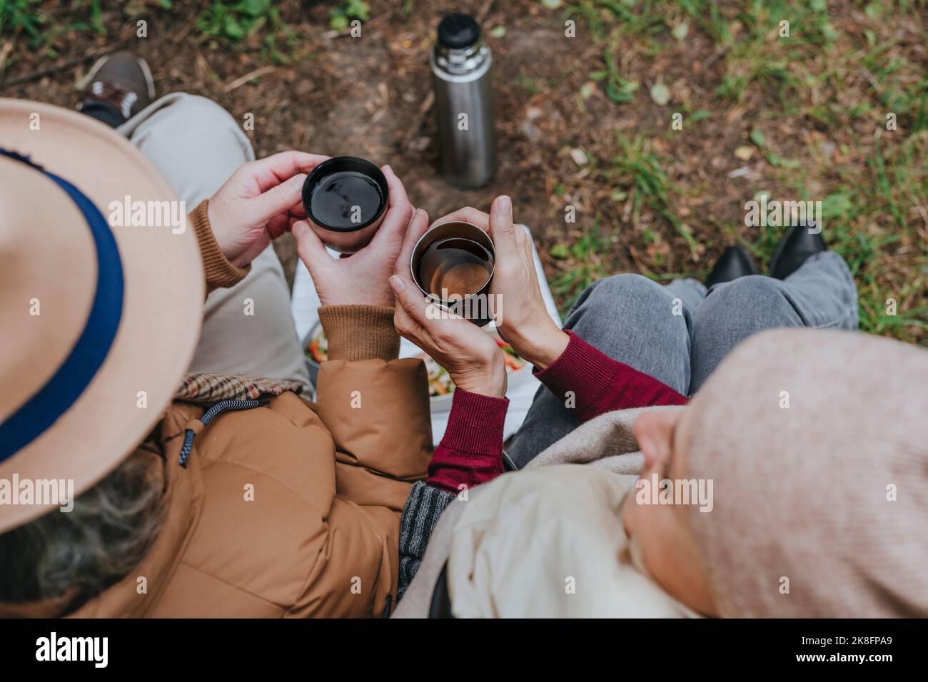 Coppia seduta con una tazza di tè nella foresta Foto Stock