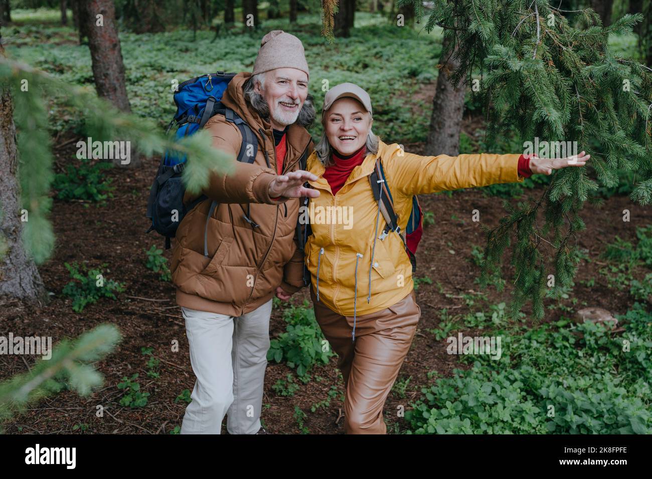 Felice coppia eterosessuale gesturing nella foresta Foto Stock