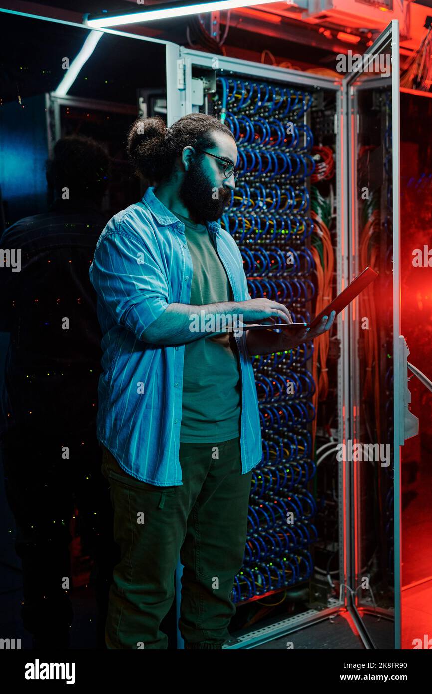 Tecnico IT che utilizza il laptop dai server del data center Foto Stock