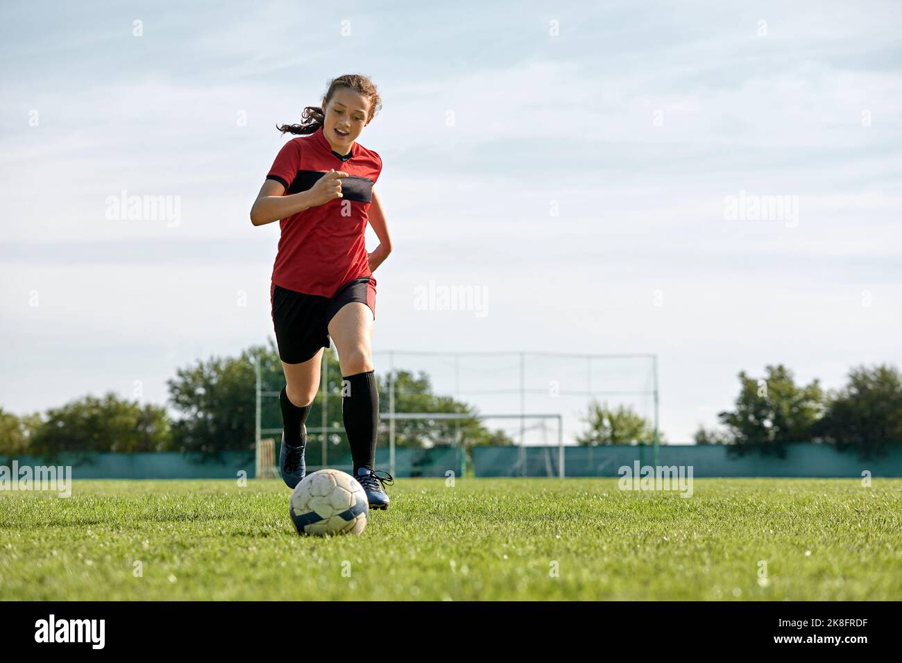 Giocatore di calcio con palla che gioca sul campo sportivo Foto Stock
