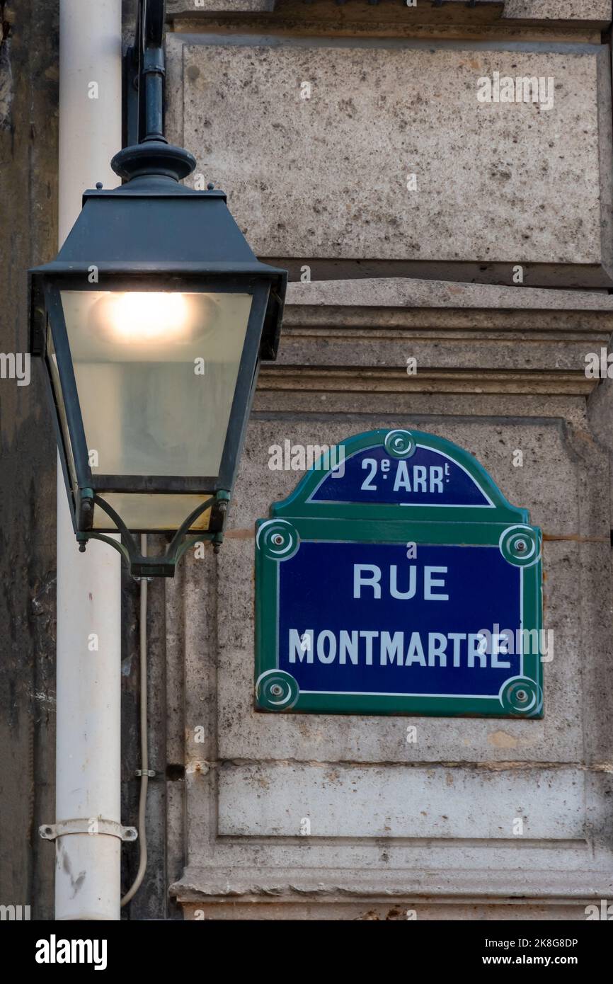 Tradizionale cartello di strada parigino con la scritta 'Rue Montmartre' accanto a una vecchia lampada di strada nel secondo arrondissement di Parigi, Francia Foto Stock