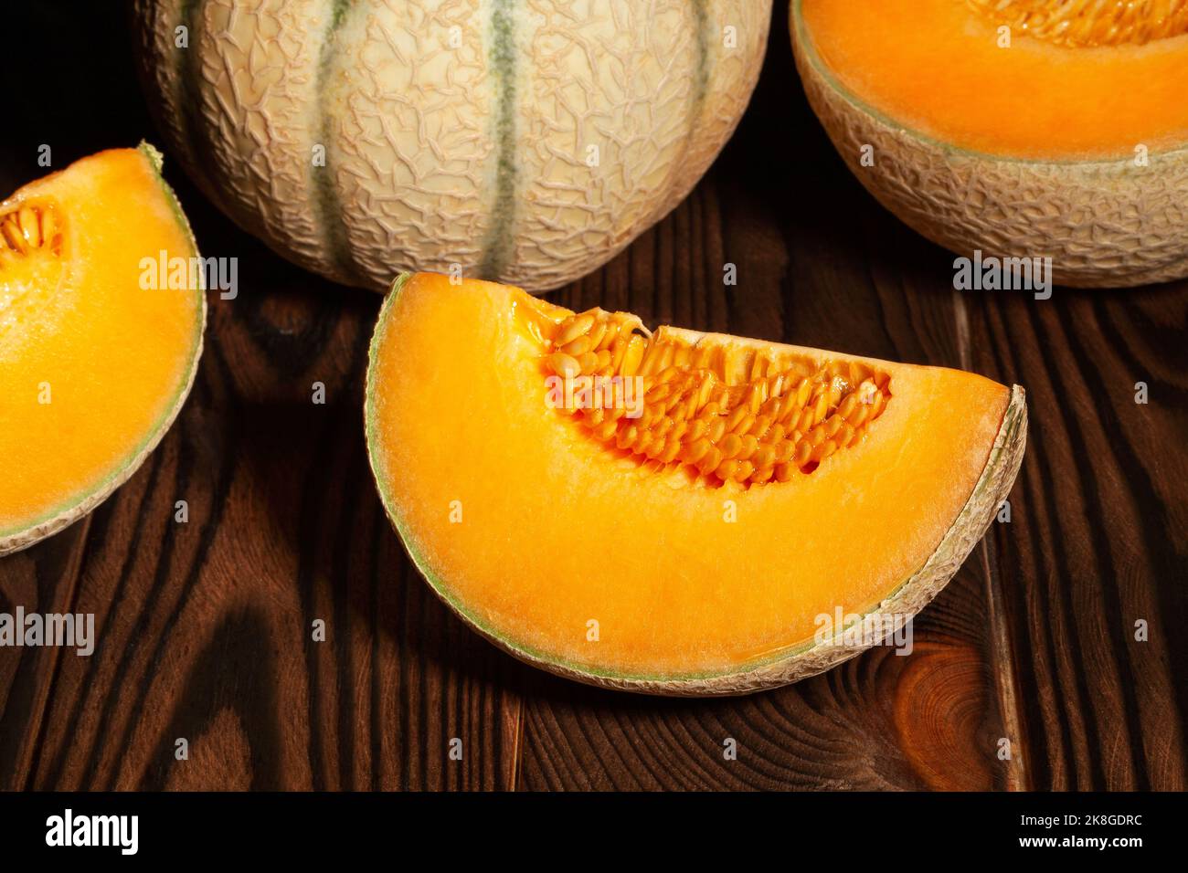 melone di cantaloupe a fette su fondo in legno Foto Stock