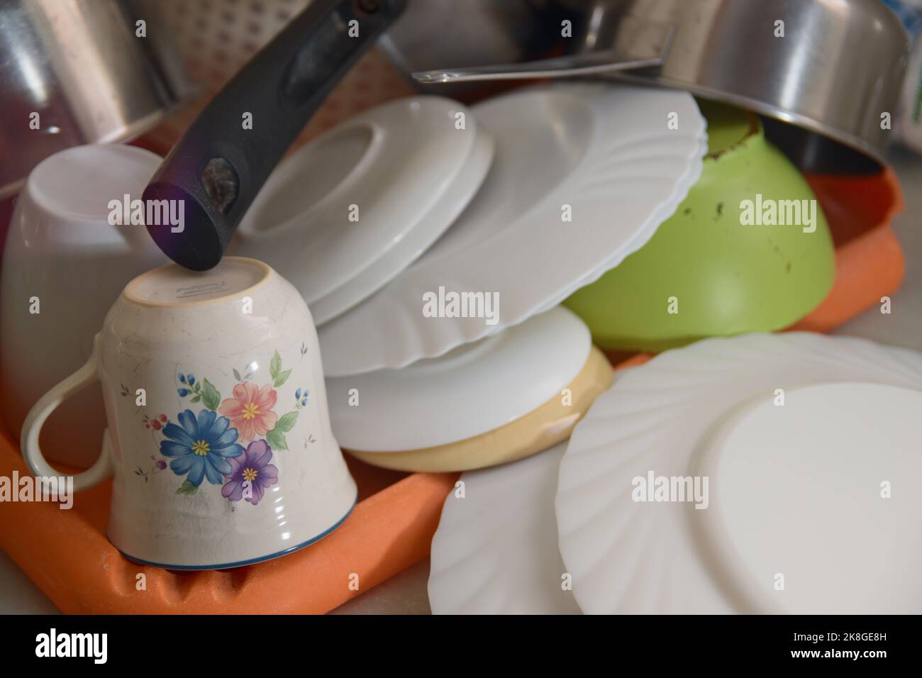 Primo piano di alcuni piatti che vengono drenati sulla panca in una cucina di famiglia dopo essere stati lavati a mano Foto Stock