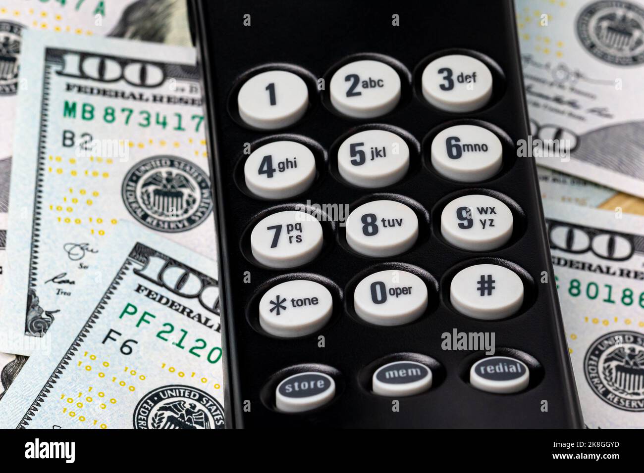 Tastiera telefonica e denaro contante. Concetto di telemarketing, furto e truffe telefoniche Foto Stock