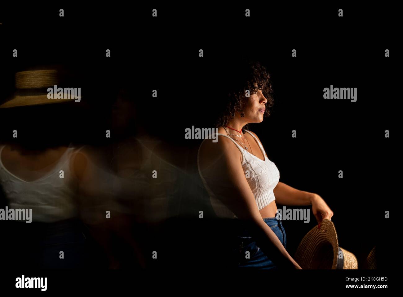 Vista temporizzata della donna che muove un cappello. Esposizione lunga, sfocatura del movimento. Donna felice. Salvador, Brasile. Foto Stock