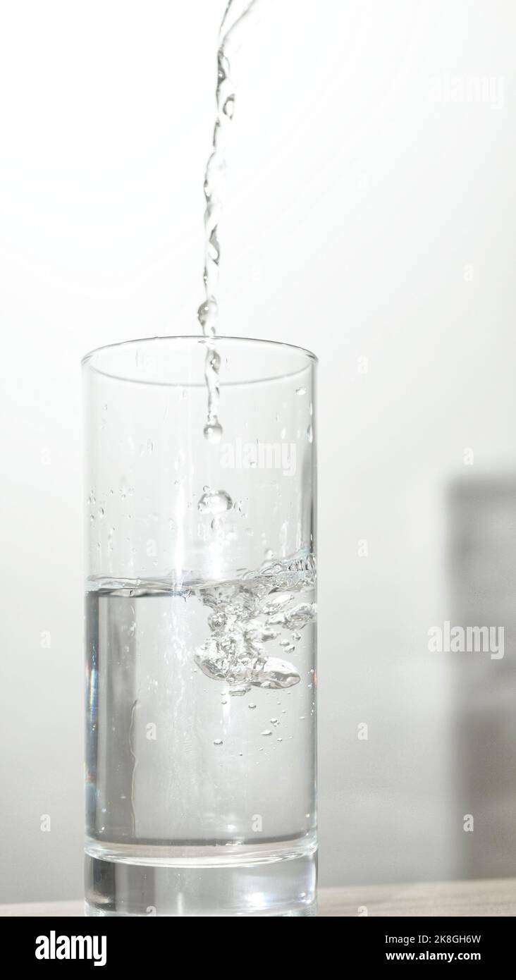 Versare l'acqua in vetro isolato su sfondo bianco con il tracciato di ritaglio Foto Stock