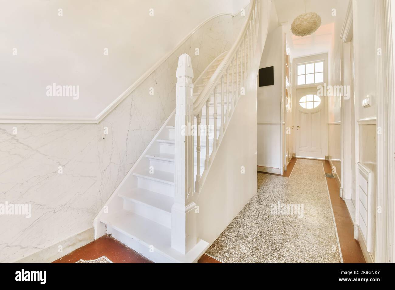 Interno di una casa con scale ad un piano superiore in un ambiente luminoso Foto Stock