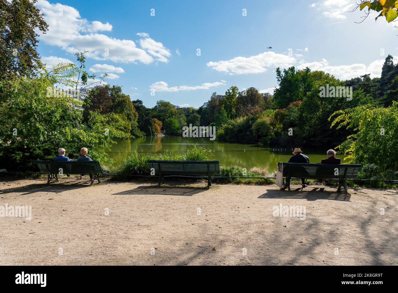 Parigini prendere il sole sulla riva del lago di Parc Montsouris - Parigi, Francia Foto Stock