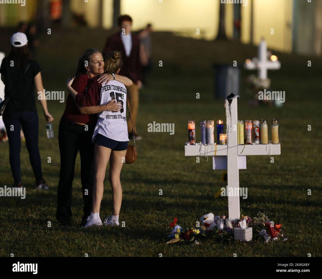 Un parco, FL - 16 febbraio: una giovane donna di fiori posti in corrispondenza di un sito commemorativo che onora le vittime della massa di scatto a Marjory Stoneman Douglas High School, Al Pine Trail Park il 16 febbraio 2018 in un parco, Florida. La polizia ha arrestato 19-anno-vecchio ex studente Nikolas Cruz per l'uccisione di 17 persone presso la scuola di alta. Persone: atmosfera Foto Stock