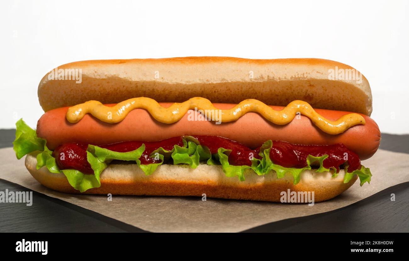 Hot dog appena cucinato si trova su carta da pergamena prima di servire Foto Stock