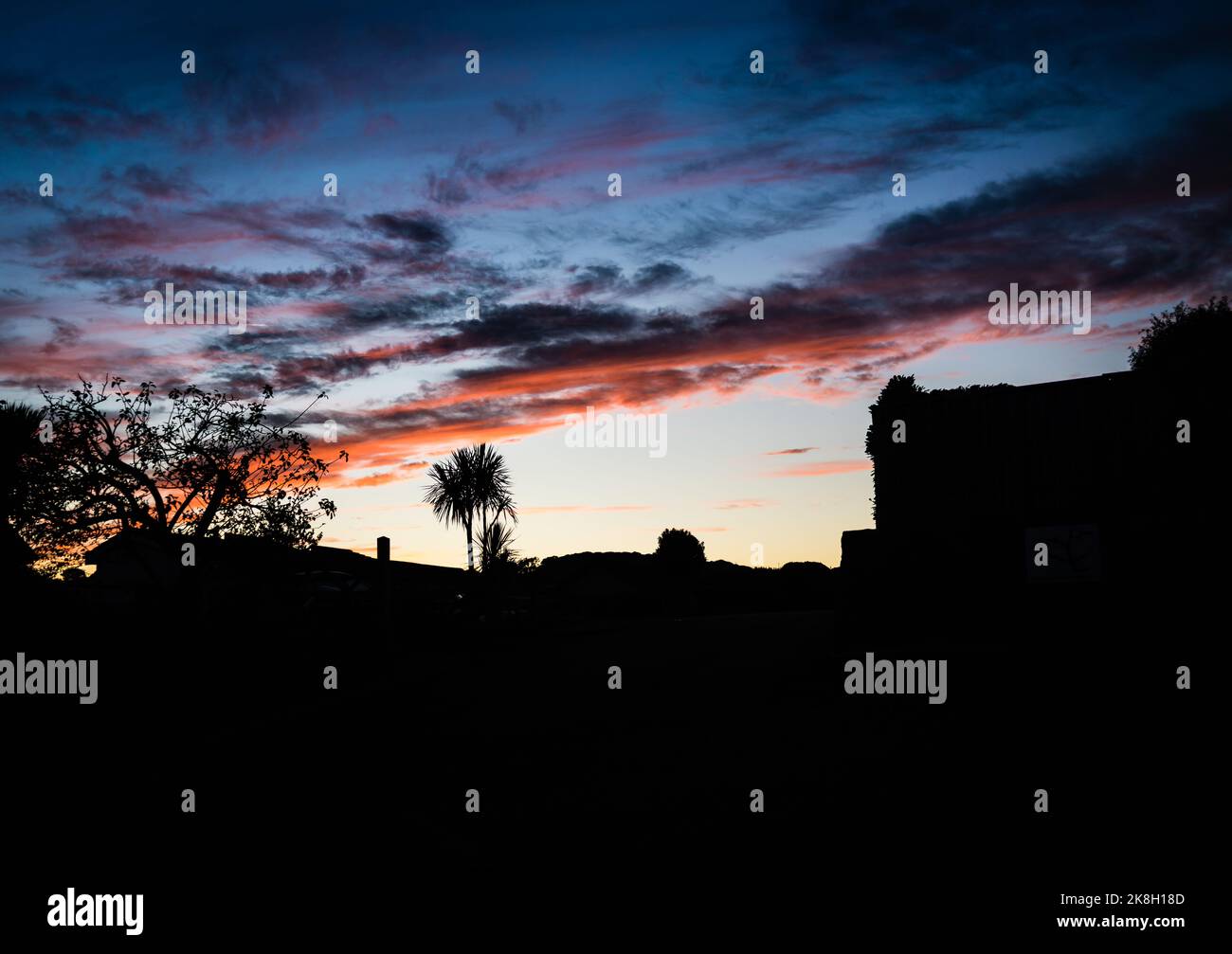 Devon Skys in autunno. Il sole tramonta sul villaggio. Foto Stock