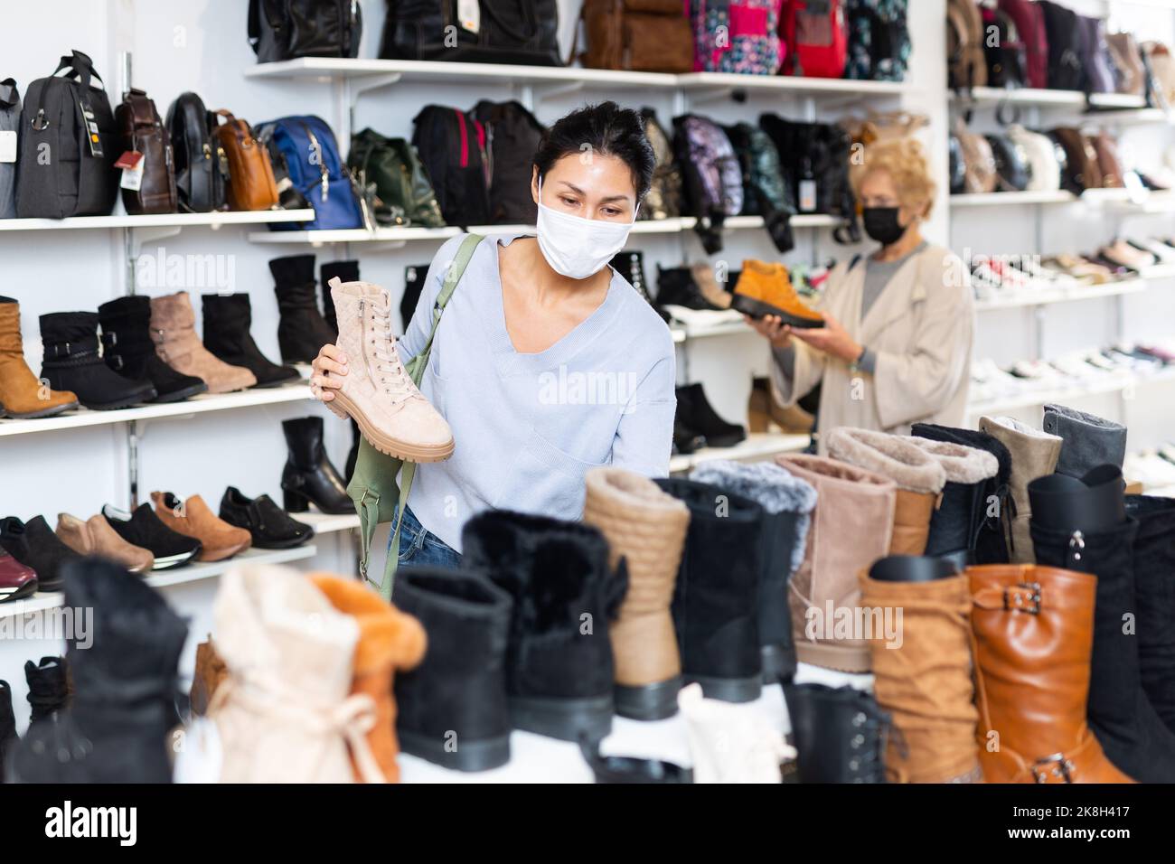 Donne in maschere shopping nel negozio di scarpe Foto Stock