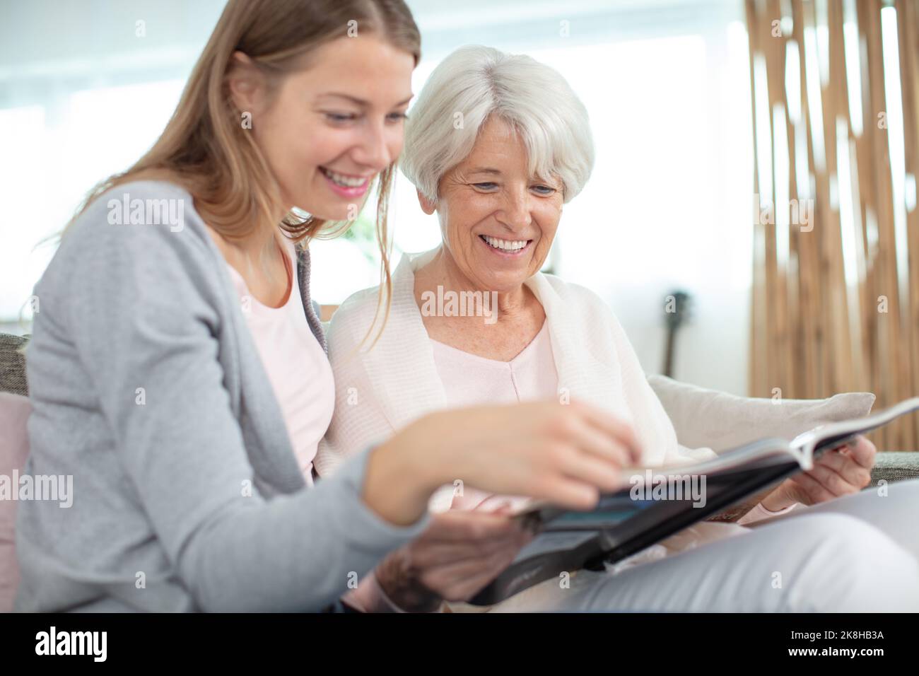 madre e figlia guardando un libro fotografico che riposa a casa Foto Stock