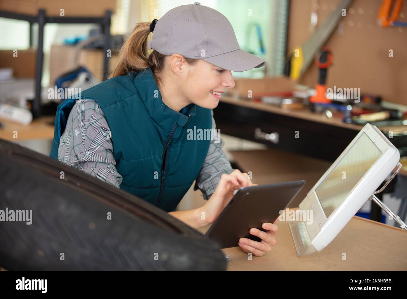 giovane donna che usa un tablet nella sua officina Foto Stock