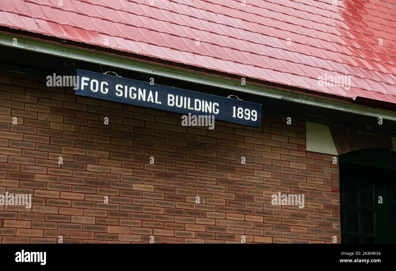Cartello di segnalazione nebbia edificio su edificio in mattoni con tetto rosso Foto Stock