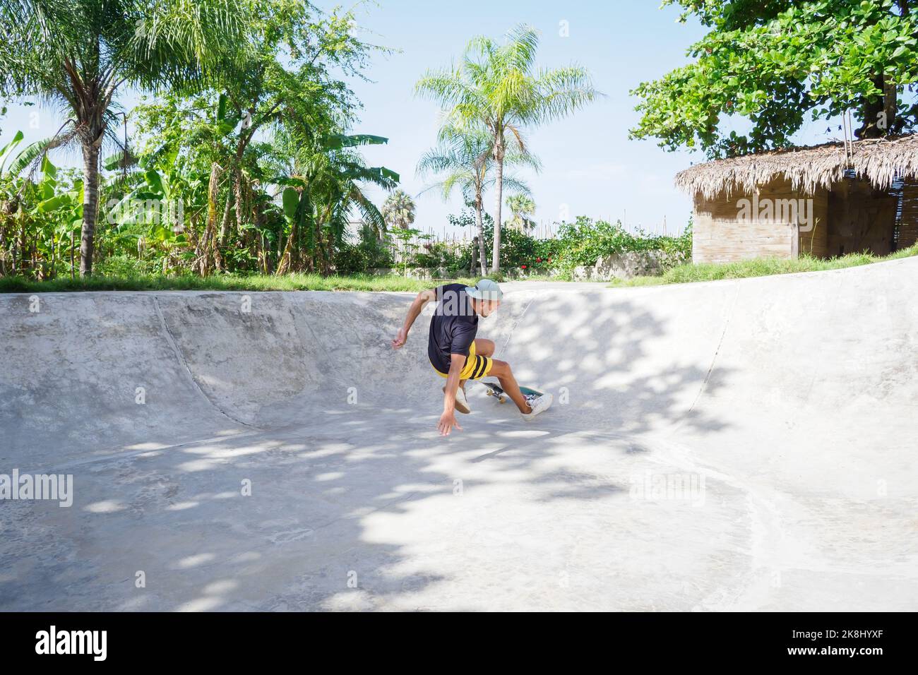 Lo skateboarder cade dallo skateboard nello skatepark Bowl. Foto Stock