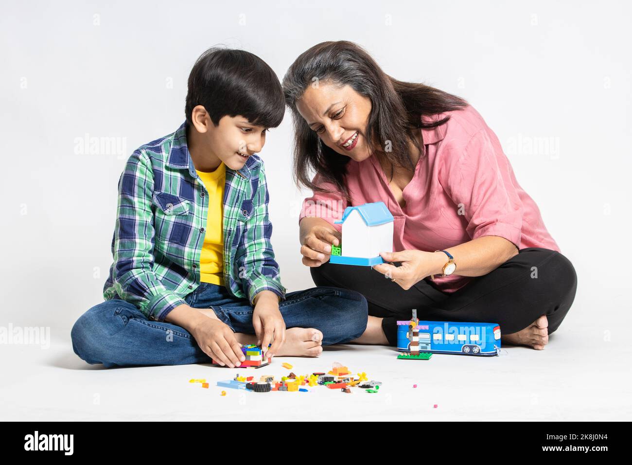 Nonna indiana felice e nipote giocare con giocattoli colorati, isolato su sfondo bianco studio, nonna insegnare Male Grandchild, apprendimento Conc Foto Stock