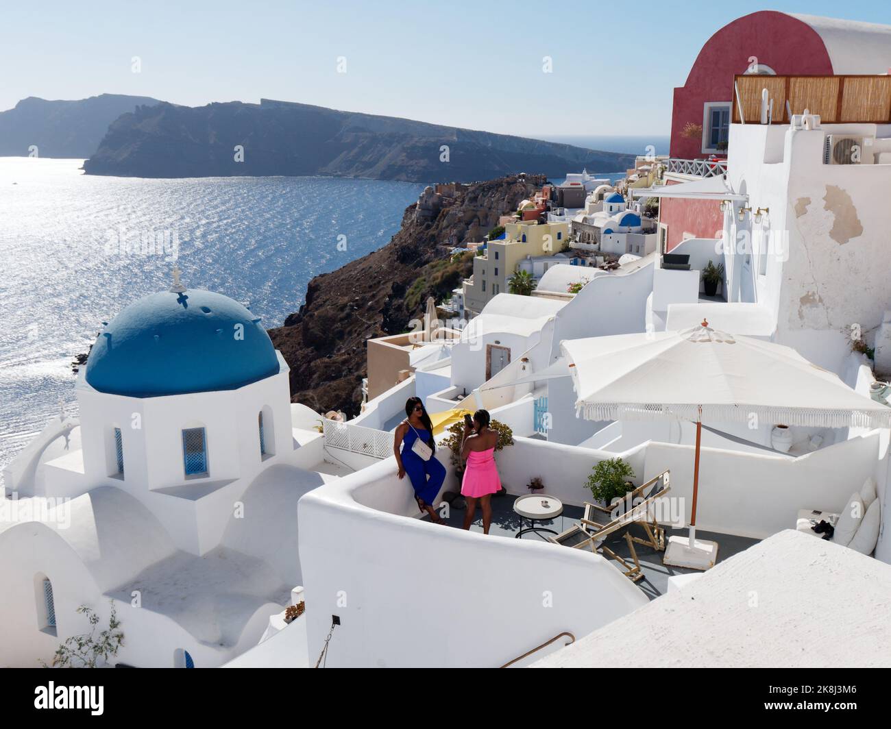 Città di Oia con boutique hotel, vacanzieri, famosi tetti blu e vista sulla Caldera. Isole Cicladi greche di Santorini nel Mar Egeo. Foto Stock