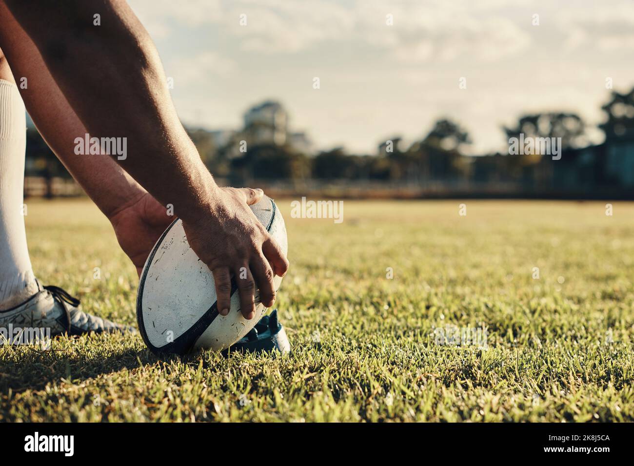 Inizia l'allenamento di calcio: Un giocatore di rugby irriconoscibile che si prepara a calciare sul campo durante il giorno. Foto Stock