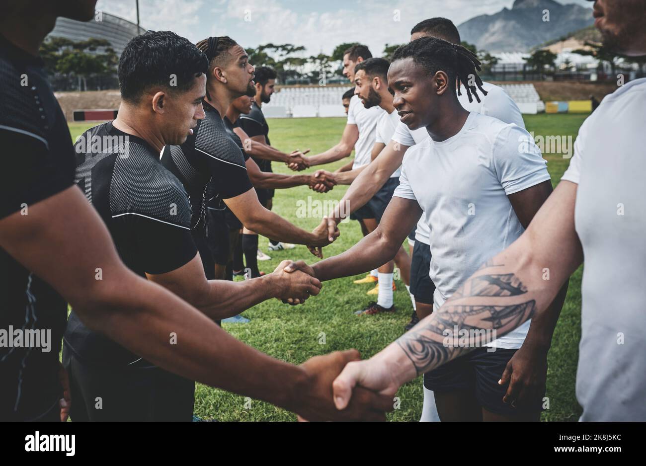 Ci vediamo la prossima volta. Un gruppo di giovani giocatori di rugby che si scuotono le mani per congratularsi per aver giocato un buon gioco all'aperto su un campo. Foto Stock