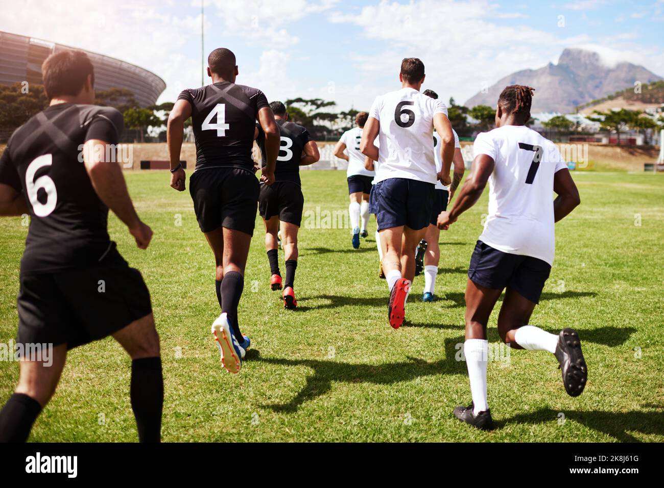 Sono arrivati i vincitori, un gruppo di giovani giocatori di rugby che corrono sul campo durante una partita. Foto Stock