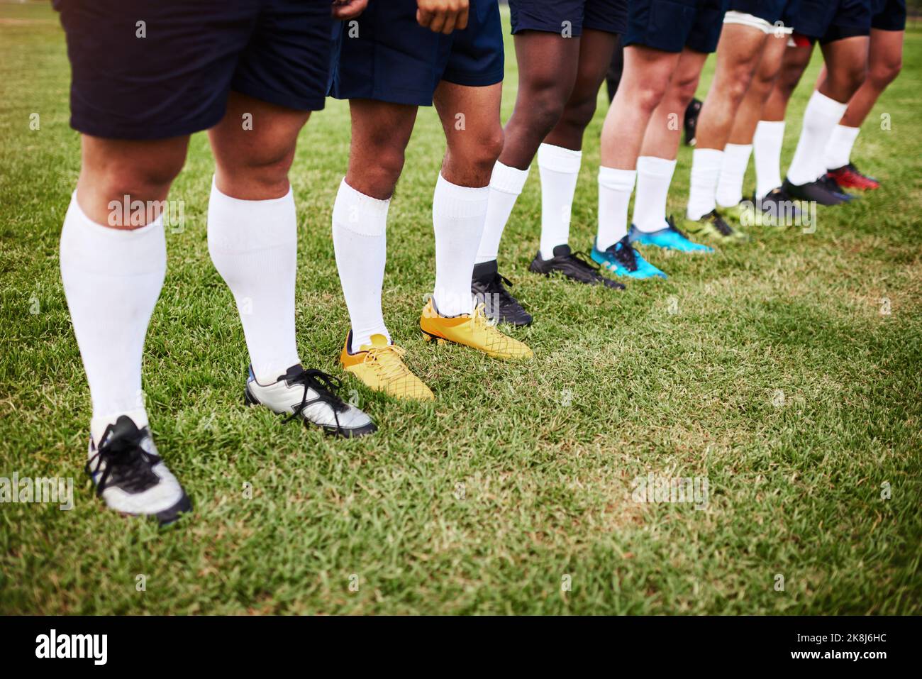 In linea per le grandi leghe. Un gruppo di giocatori di rugby in piedi insieme in una linea sul campo. Foto Stock