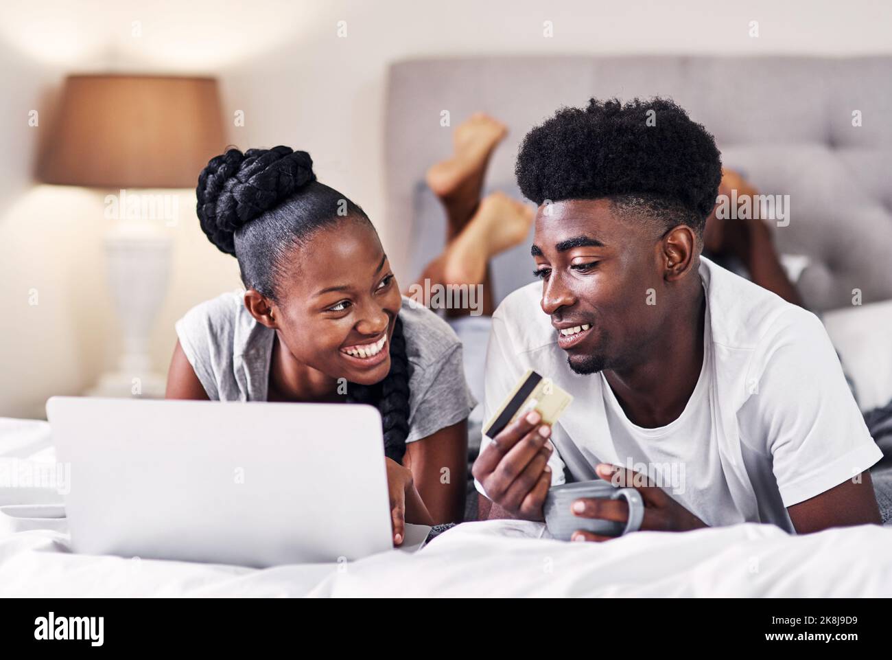Credo che dovremmo iscriverci: Una giovane coppia che usa una carta di credito mentre naviga in rete. Foto Stock