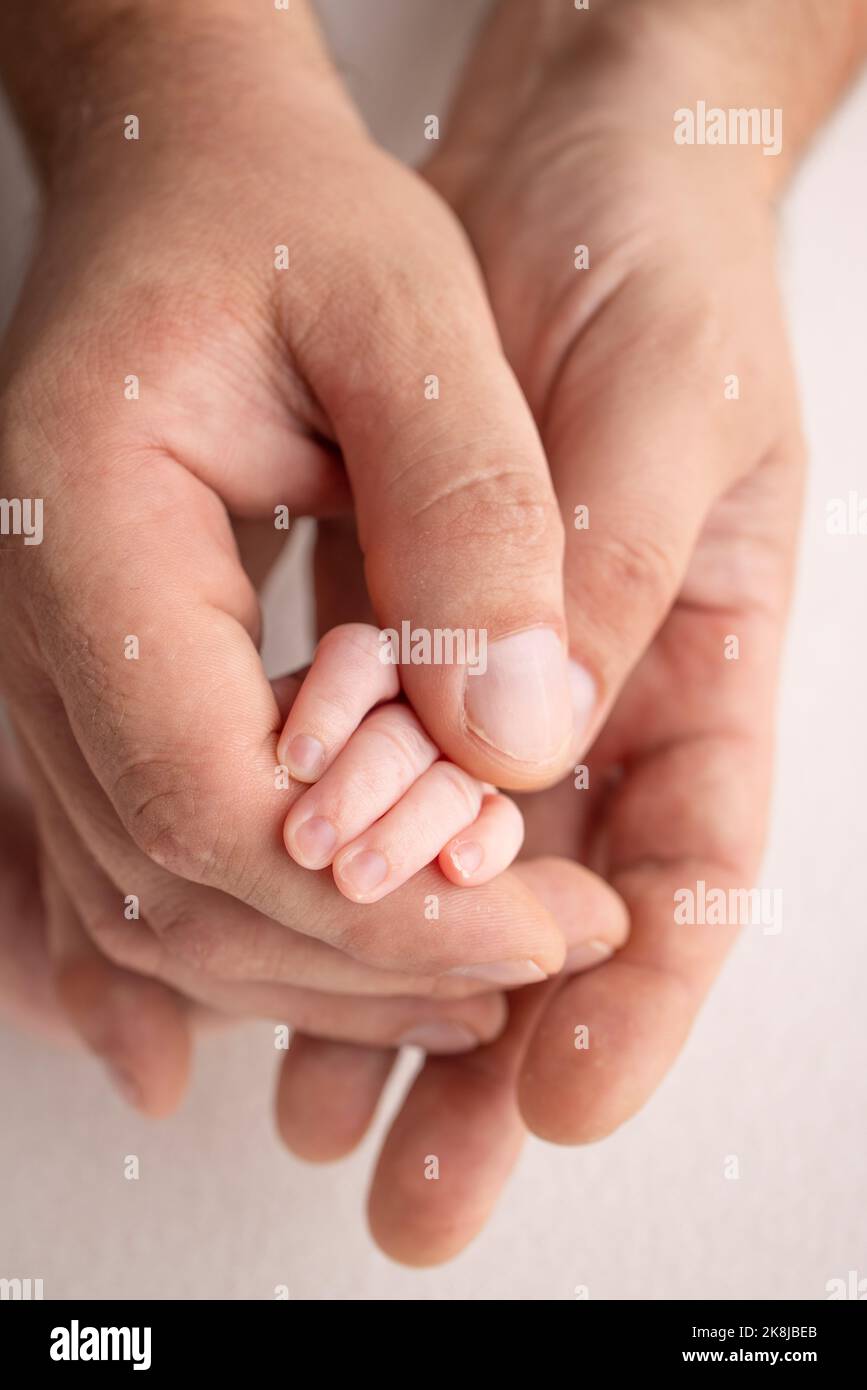 La mano del neonato che dorme nella mano dei genitori, madre e padre primo piano Foto Stock