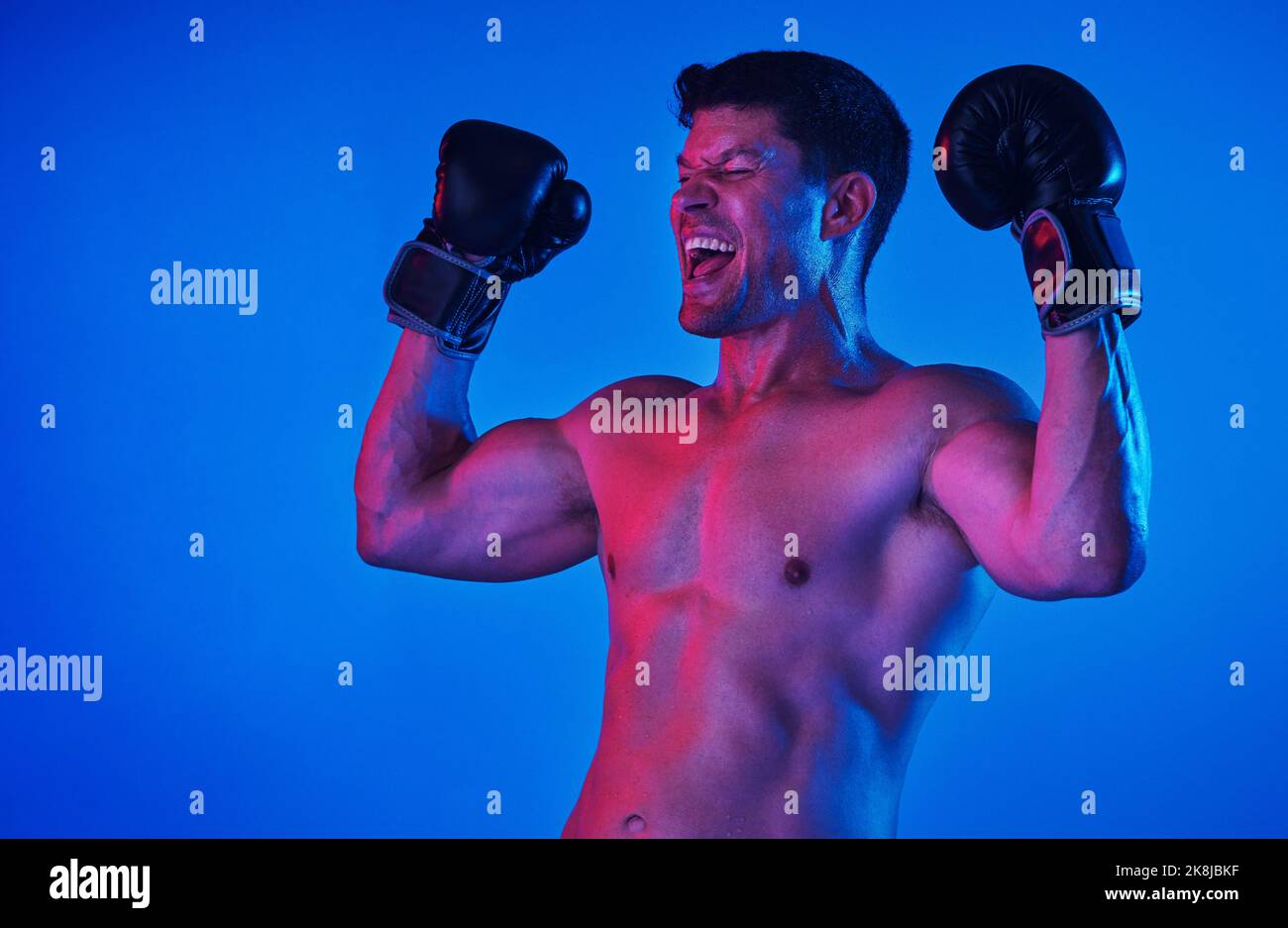 L'abitudine della persistenza è l'abitudine della vittoria. Colpo filtrato blu di uno sportivo che indossa guanti da boxe mentre si posa in studio. Foto Stock