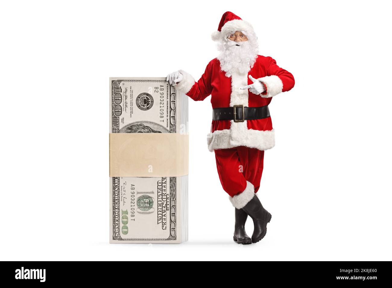 Babbo natale appoggiato su una pila di soldi e puntando isolato su sfondo bianco Foto Stock