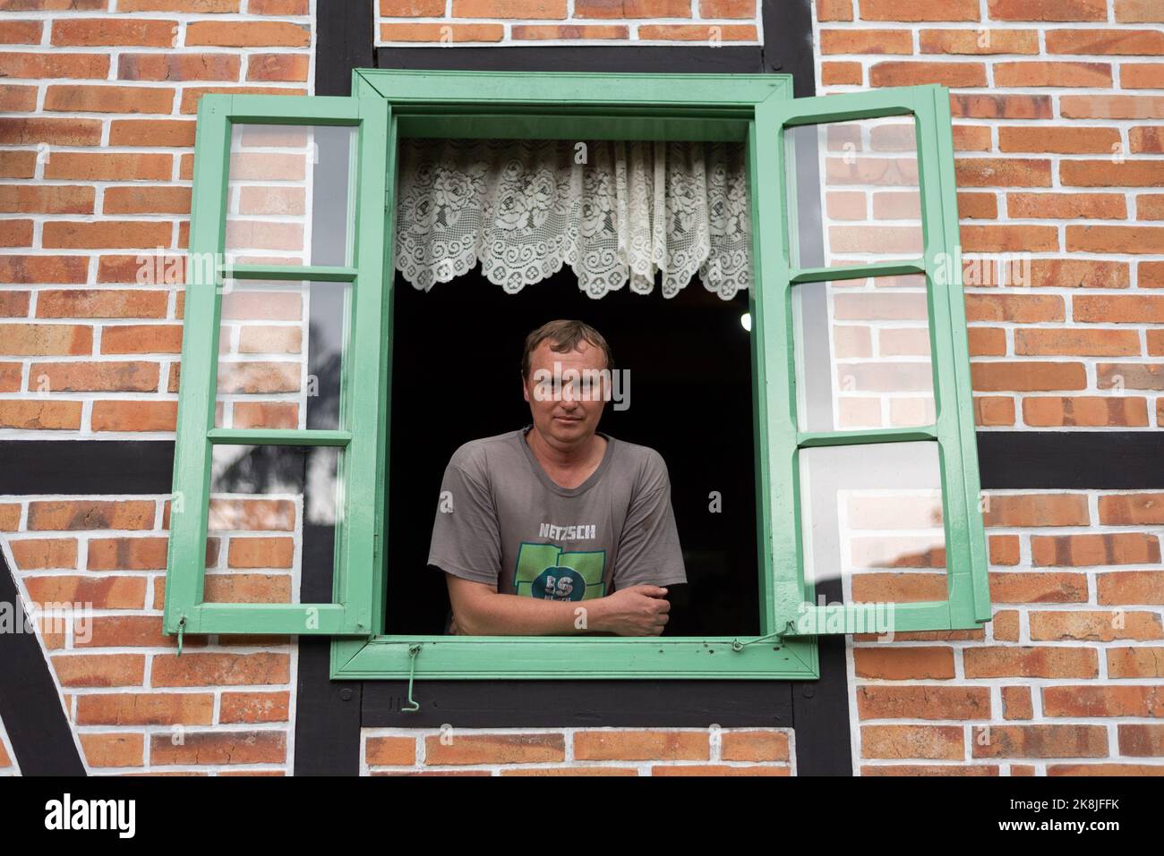 Pomerode, Brasile. 27th Set, 2022. Rogerio Siewert, la sesta generazione di immigrati tedeschi, guarda fuori da una finestra. Siewert è un sostenitore di Bolsonaro ed è convinto che tutte le informazioni che riceve attraverso i gruppi Whatsapp a sostegno del leader brasiliano siano vere. Credit: Henry Milleo/dpa/Alamy Live News Foto Stock