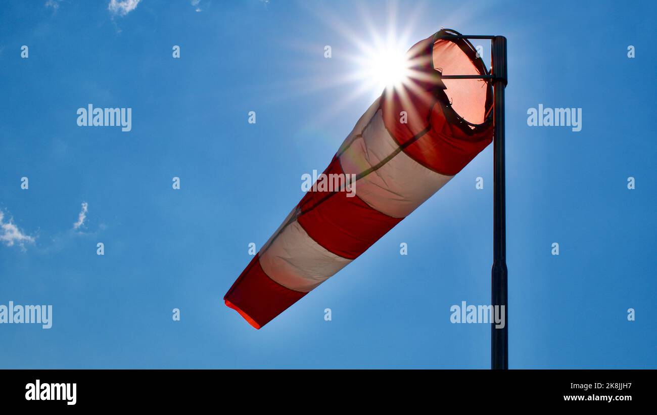 Calzino per vento. Bandiera Windsock. Indicatore di direzione del vento. Intensità del vento. Windsock di fronte al cielo blu. Foto Stock