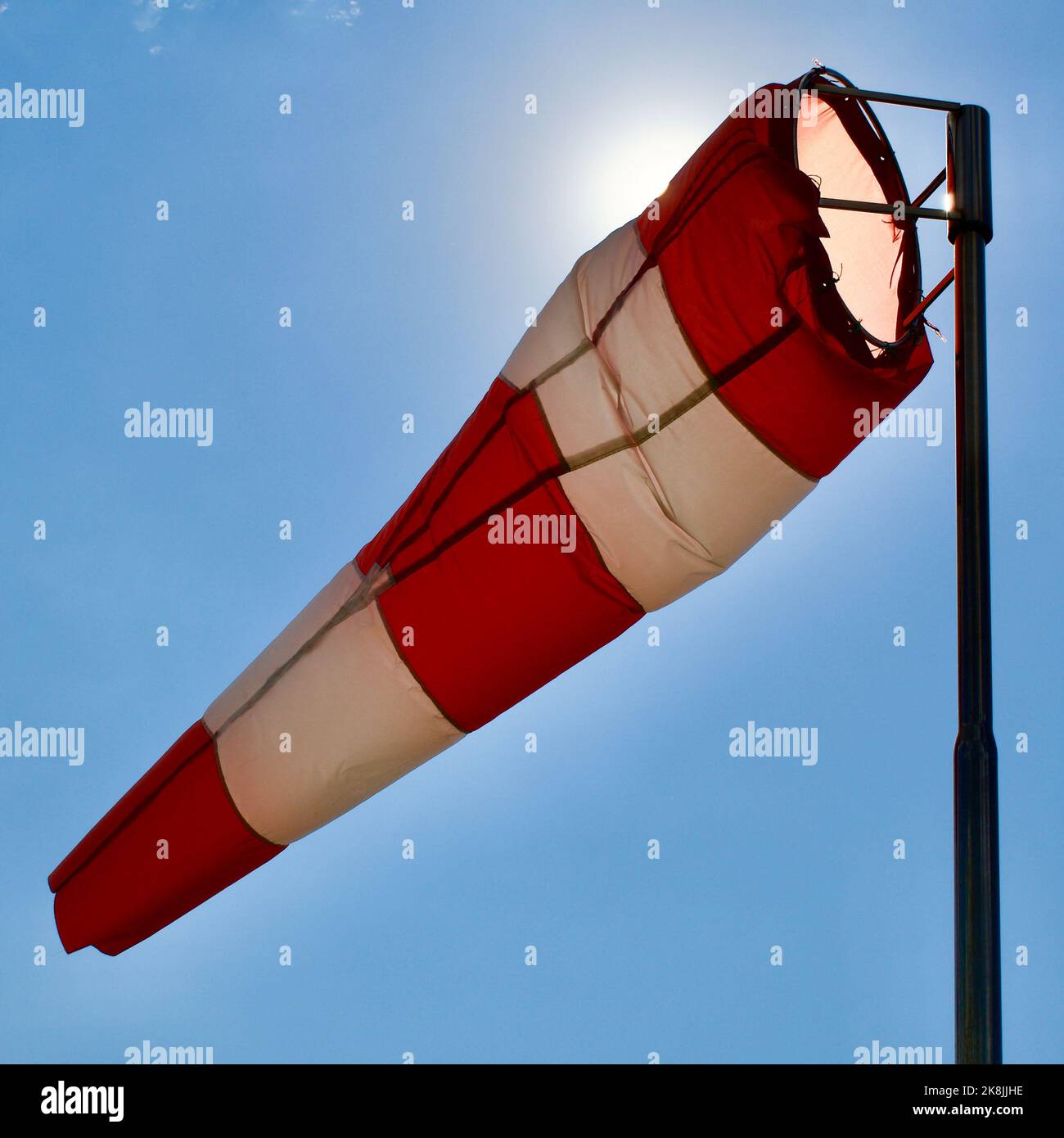 Calzino per vento. Bandiera Windsock. Indicatore di direzione del vento. Intensità del vento. Windsock di fronte al cielo blu. Foto Stock
