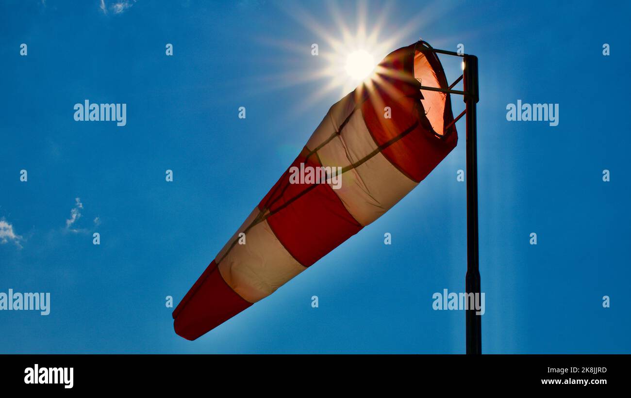 Calzino per vento. Bandiera Windsock. Indicatore di direzione del vento. Intensità del vento. Windsock di fronte al cielo blu. Foto Stock