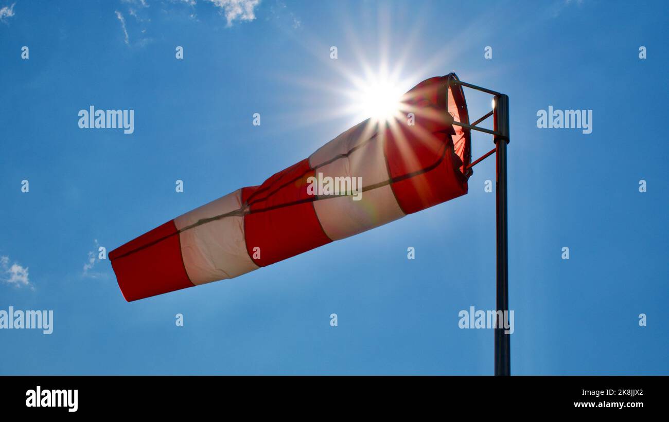 Calzino per vento. Bandiera Windsock. Indicatore di direzione del vento. Intensità del vento. Windsock di fronte al cielo blu. Foto Stock