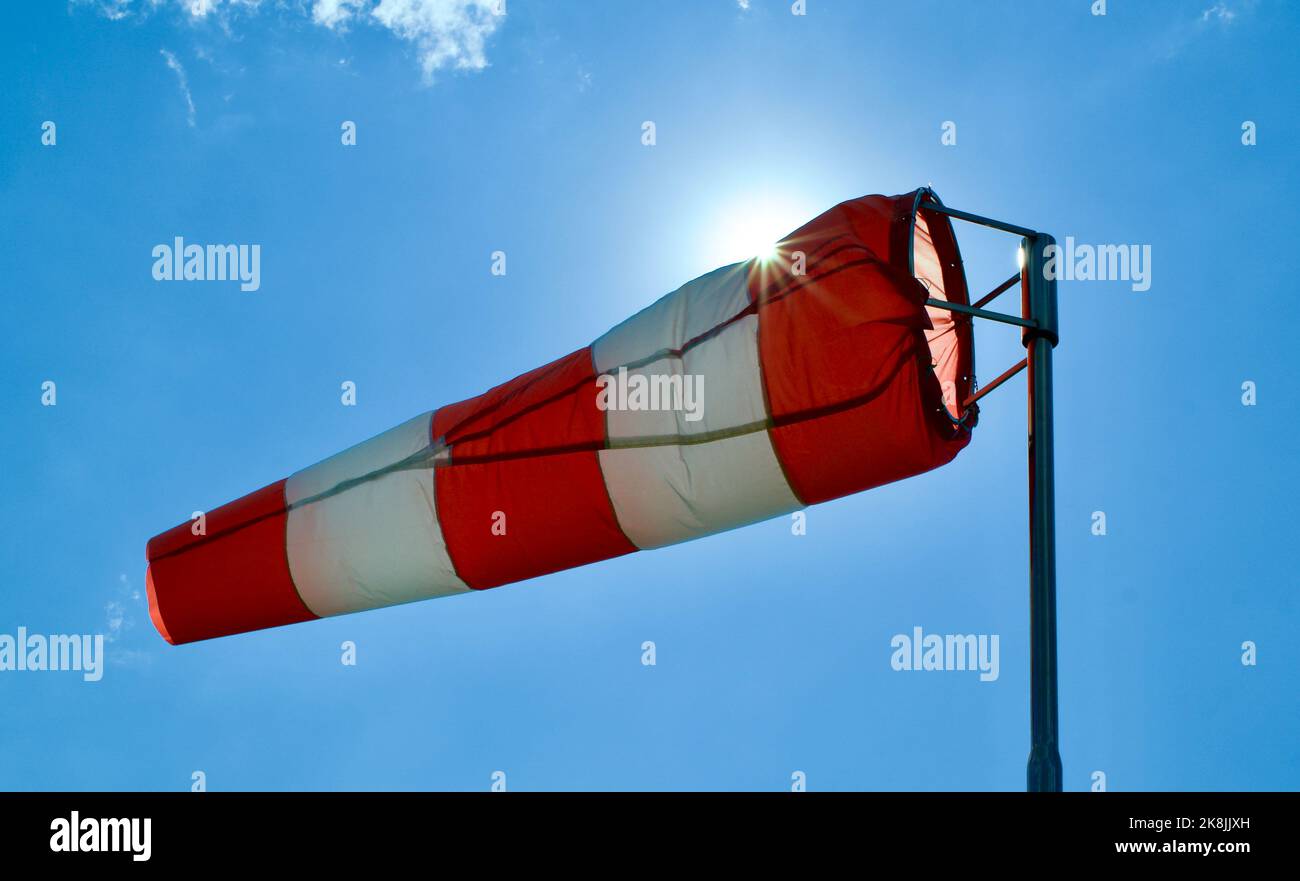 Calzino per vento. Bandiera Windsock. Indicatore di direzione del vento. Intensità del vento. Windsock di fronte al cielo blu. Foto Stock