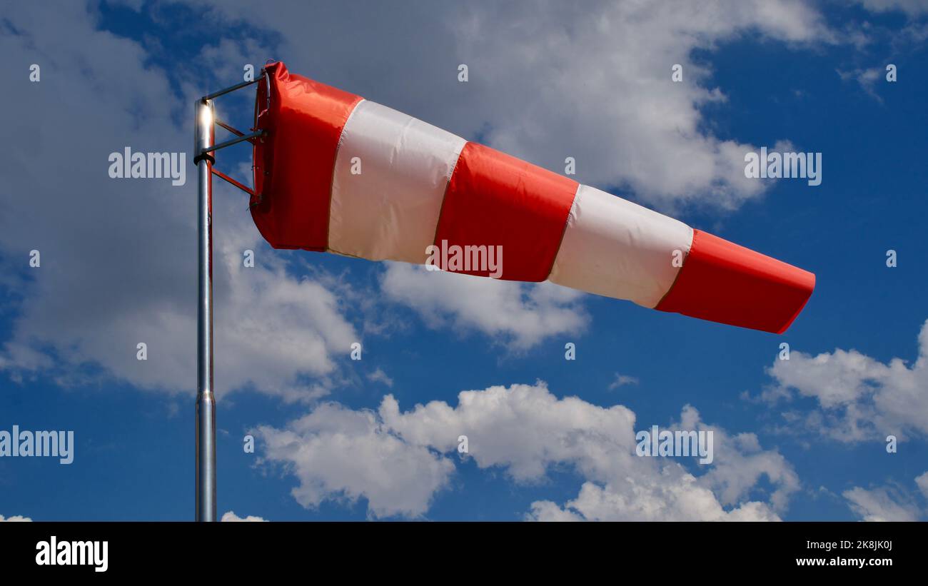 Calzino per vento. Bandiera Windsock. Indicatore di direzione del vento. Intensità del vento. Windsock di fronte al cielo blu. Foto Stock
