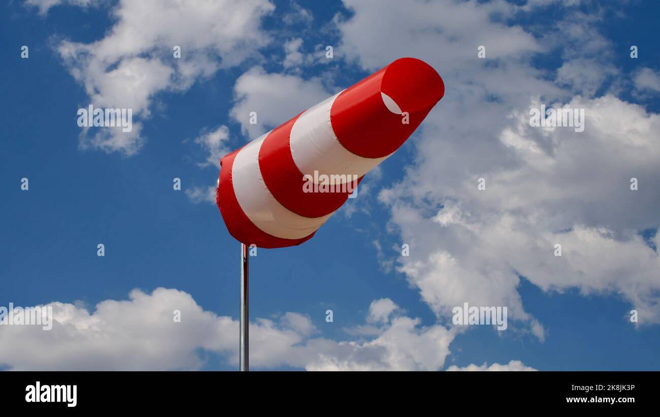 Calzino per vento. Bandiera Windsock. Indicatore di direzione del vento. Intensità del vento. Windsock di fronte al cielo blu. Foto Stock