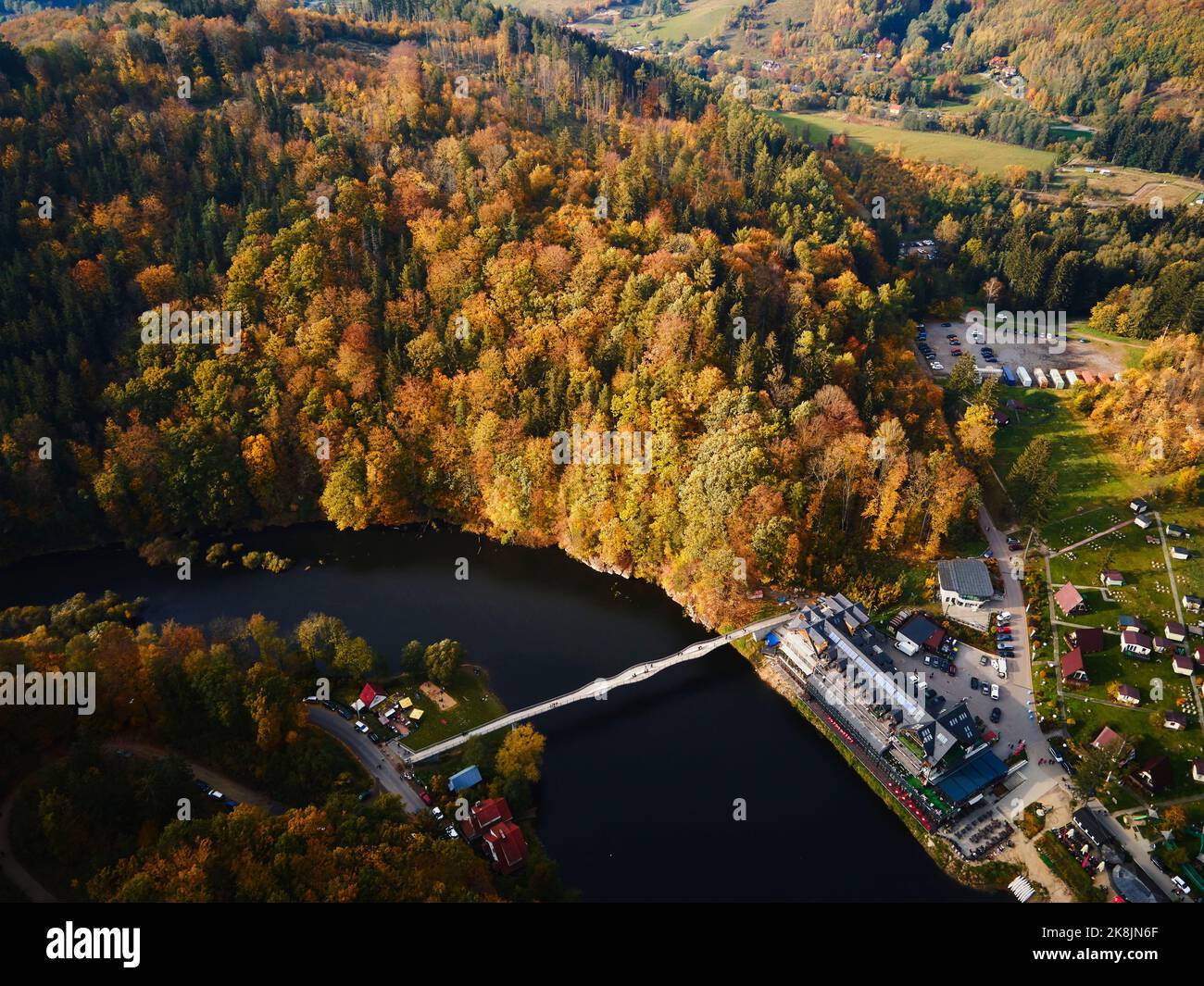 Area ricreativa vicino al castello di Grodno a Zagorze, Polonia. Splendido paesaggio autunnale con montagne ricoperte di foresta, fiume e ponte per le persone che lo sovrastano Foto Stock