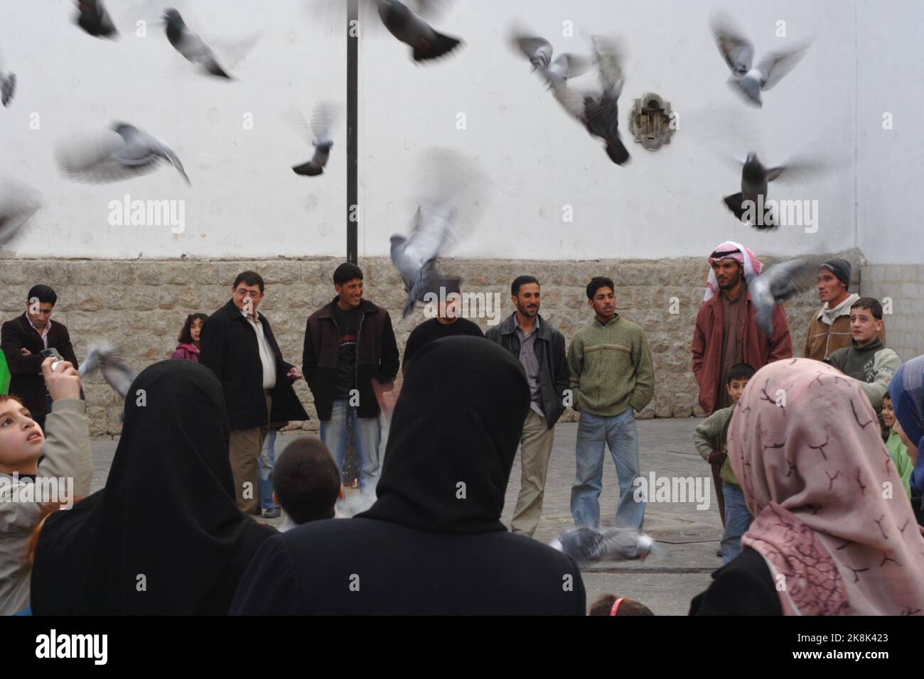 Un gregge di piccioni che prendono il volo sorvegliato da persone, Damasco, Siria Foto Stock