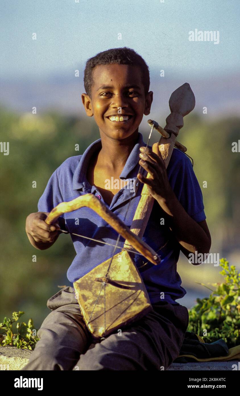 Etiopia, Addis Abeba; Ritratto di un ragazzo che gioca il masinko tradizionale etiope o chira-wata. Il Masenqo è un liuto ad arco singolo comunemente fou Foto Stock